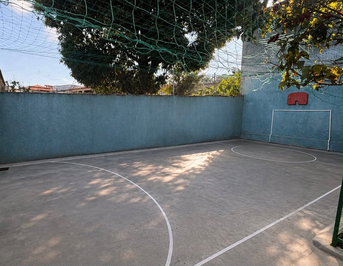 Quadra da escola com gol e sombra das árvores